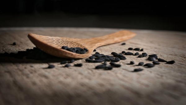 Jinten hitam di atas sendok kayu sebagai ilustrasi bahan alami yang diteliti.