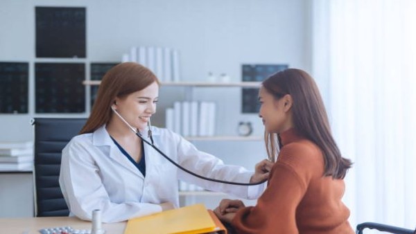 Seorang wanita dewasa memeriksa kondisi tubuhnya sambil mencari informasi kesehatan terkait hormon.