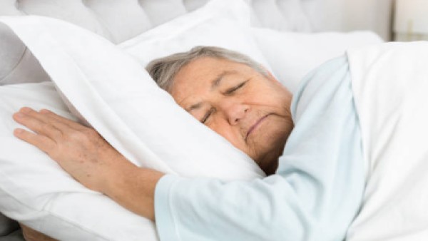 Gambar seorang lansia yang sedang tertidur nyenyak di ranjang, menunjukkan betapa pentingnya kualitas tidur yang baik untuk kesehatan otak dan tubuh.