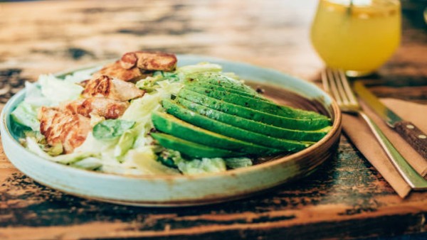 Ilustrasi menu makanan sehat seperti salad ayam dan alpukat yang dikaitkan dengan suasana hati lebih stabil dan bahagia.