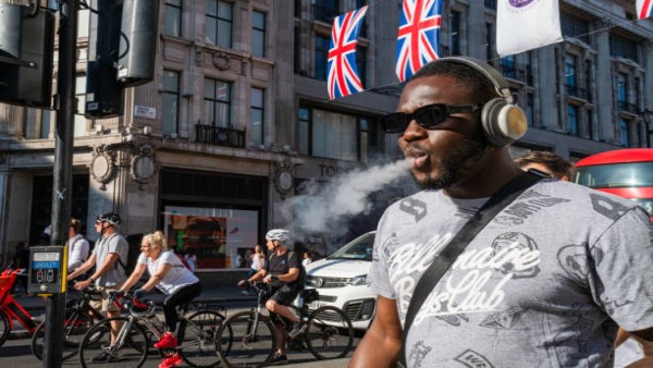 Orang terlihat merokok di London, Inggris, menggambarkan kebiasaan lama yang kini mulai dibatasi oleh kebijakan larangan rokok generasi baru.
