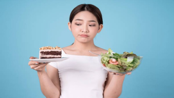 Ilustrasi perempuan memilih salad sehat dibanding kue manis untuk mengurangi konsumsi gula harian.