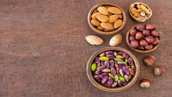 Ilustrasi aneka kacang-kacangan seperti pistachio, kenari, dan almond yang direkomendasikan ahli sebagai camilan sehat untuk membantu menjaga tekanan darah.